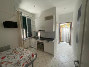 a kitchen with white cabinets and a bed in a room at La Casetta in La Spezia