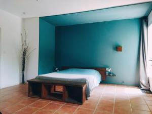 um quarto com uma cama e uma parede azul em Aur Blan - Chambres Le Somail em Le Somail
