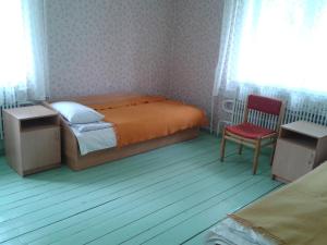 1 dormitorio con 1 cama y 1 silla roja en Rubeni, en Pilskalne