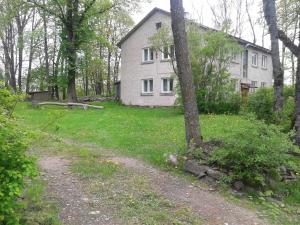 a dirt road in front of a white house at Rubeni in Pilskalne