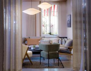 a living room with a couch and a chair at Hôtel Marais de Launay in Paris