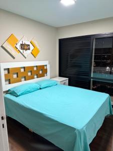 a bedroom with a blue bed with a window at Apartamento Top Morumbi in São Paulo