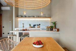 a kitchen with a wooden table with a bowl of fruit at Baia Dorata beach apartments in Porto Istana