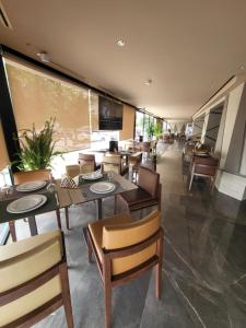 un ristorante con tavoli e sedie e una grande finestra di Hotel Appartement Tanger a Tangeri