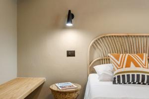 a bedroom with a bed with a wooden headboard and a table at Baia Dorata beach apartment in Porto Istana