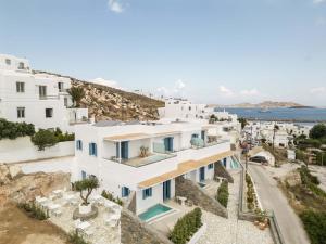 an aerial view of a white building with the ocean in the background at Aura Suites Paros in Naousa