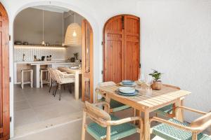 a kitchen and dining room with a wooden table and chairs at Baia Dorata beach apartments in Porto Istana