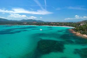 an aerial view of a beach with a boat in the water at Baia Dorata beach apartments in Porto Istana