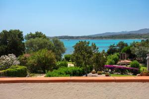 a view of a garden with a view of the water at Baia Dorata beach apartments in Porto Istana