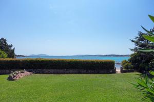 a garden with a view of the water at Baia Dorata beach apartments in Porto Istana