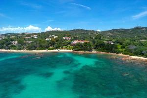 an aerial view of a beach with turquoise water at Baia Dorata beach apartments in Porto Istana