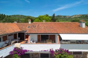 a view of a house with an orange tile roof at Baia Dorata beach apartments in Porto Istana