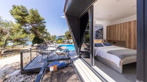 a bedroom with a bed and a balcony with a pool at Porton Nature Hideouts in Rovinj