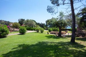 a park with a bench and trees and grass at Baia Dorata beach apartments in Porto Istana