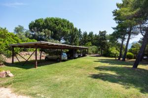 a picnic shelter with a car parked in a park at Baia Dorata beach apartments in Porto Istana