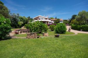 a yard with a house in the background at Baia Dorata beach apartments in Porto Istana