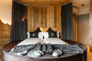 a bedroom with a large bed with blankets and pillows at Araldo Eco-Lodge in Bosco Chiesanuova