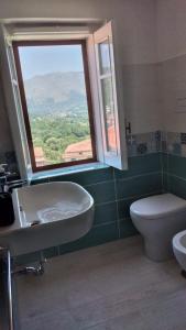 a bathroom with a sink and a toilet and a window at La Dolce Vita in Camerota