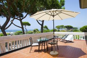 d'une table, de chaises et d'un parasol sur le balcon. dans l'établissement Casa per ferie Il Pioppo, à Marina di Massa