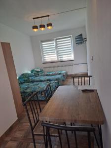 a room with two beds and a table and chairs at Noclegi u Wandy in Ropienka +10 photos