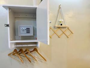 a white cabinet with a microwave and wooden hangers at Panari Lodge El Nido in El Nido