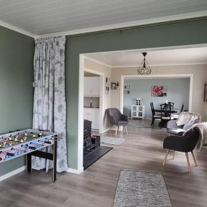 - un salon avec un baby-foot et un canapé dans l'établissement Koselig hus med hage i Herøy på Sunnmøre., 