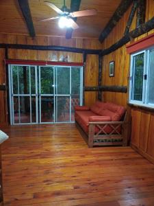 ein Wohnzimmer mit einem Sofa und einem großen Fenster in der Unterkunft Yasí Yateré Reserva Agroecológica in El Soberbio