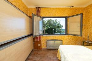 een slaapkamer met een bed, een raam en een tv bij Agriturismo La Meria in Semproniano