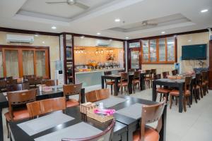 a restaurant with tables and chairs and a kitchen at DUC MINH HOTEL in Ho Chi Minh City