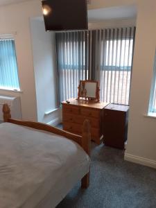 um quarto com uma cama, uma cómoda e janelas em Southbay Room 2 em Bridlington