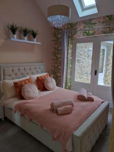 a bedroom with a large bed with pillows on it at Tree Fern Barn in St Austell