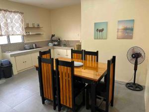 a kitchen with a wooden table and chairs and a fan at Cozy Apartment near beach in San Fernando