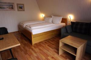 a small bedroom with a bed and a couch at Hotel Pension Julia in Norddeich