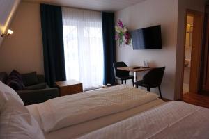 a hotel room with a bed and a table with chairs at Hotel Pension Julia in Norddeich