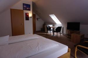 a bedroom with a bed and a table with chairs at Hotel Pension Julia in Norddeich