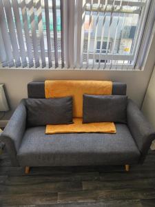 a couch with two pillows sitting in front of a window at City Centre Studios 1 in Leicester