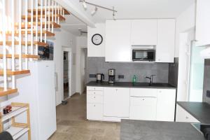 a kitchen with white cabinets and a sink at FeWo Bayha "Im blauen Haus" in Langenargen