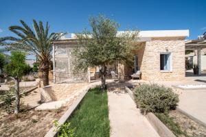 a stone house with a garden in front of it at TERRA E SOLE spa suite Aegina in Vathí