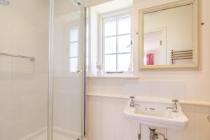 a bathroom with a shower and a sink and a mirror at Fig Cottage in Eastdean +5 photos