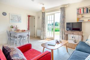a living room with a couch and a table at Fig Cottage in Eastdean