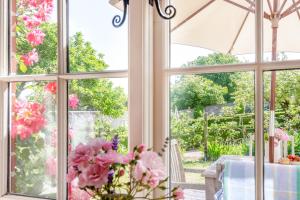 a room with windows looking out onto a garden at Fig Cottage in Eastdean