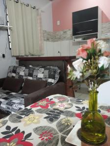 a living room with a table with a vase of flowers at Chalés Alto Da Estância in Alto Paraíso de Goiás