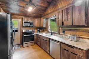 a kitchen with wooden cabinets and a black refrigerator at Eagle Ridge Creek in Banner Elk +21 photos