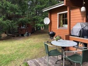 einen Grill und einen Tisch und Stühle auf einer Terrasse in der Unterkunft Holiday Cabin Kerimaa 41 in Savonlinna