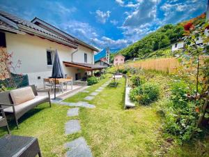 a garden with a couch and a table and chairs at • Boutique Villa 26 • in Gambarogno in Gambarogno