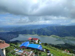 a house on top of a hill next to a lake at Sarangkot Hotel New Galaxy in Pokhara