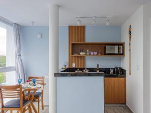 a kitchen with a counter and a table with chairs at Pousada Santorini in Búzios