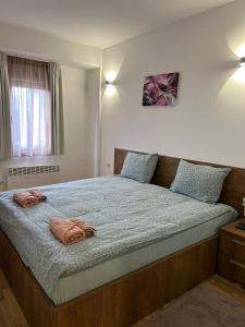 a bedroom with a large bed with two pillows on it at Domini LakeView Apartment in Mavrovo