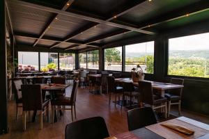 a restaurant with tables and chairs and large windows at Araldo Eco-Lodge in Bosco Chiesanuova