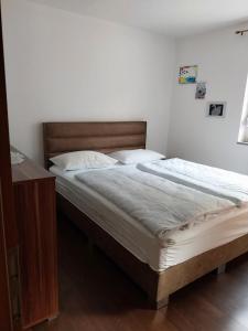 a bedroom with a large bed with a wooden headboard at Apartma Mira in Zgornje Škofije